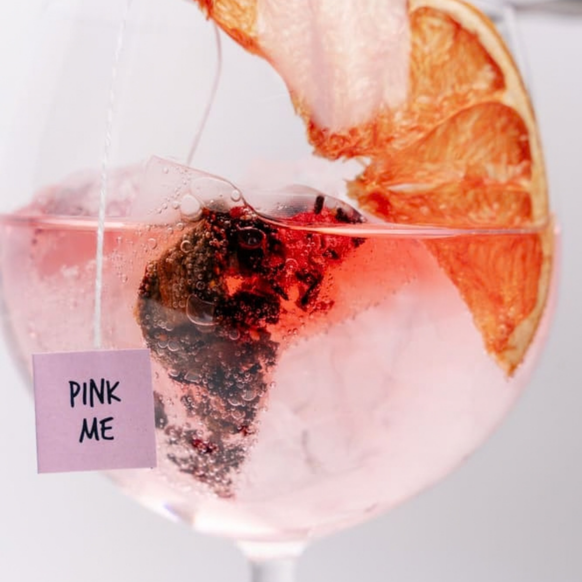 Gros plan sur le sachet Pink Me qui infuse dans le cocktail