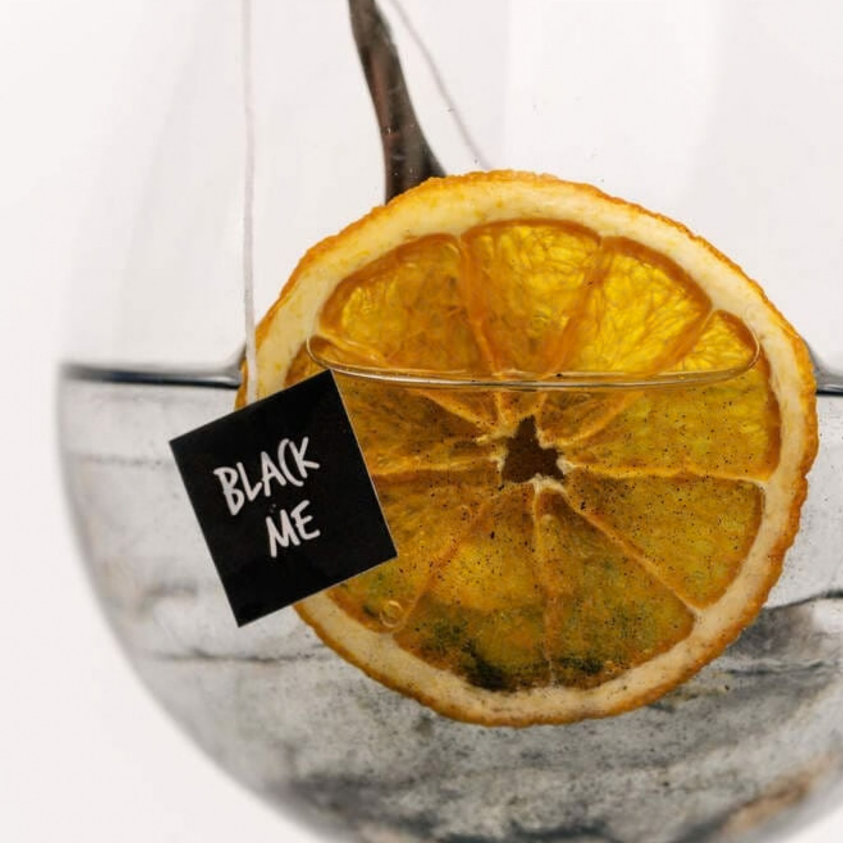 Gros plan sur le cocktail Black Me et sa rondelle d'orange