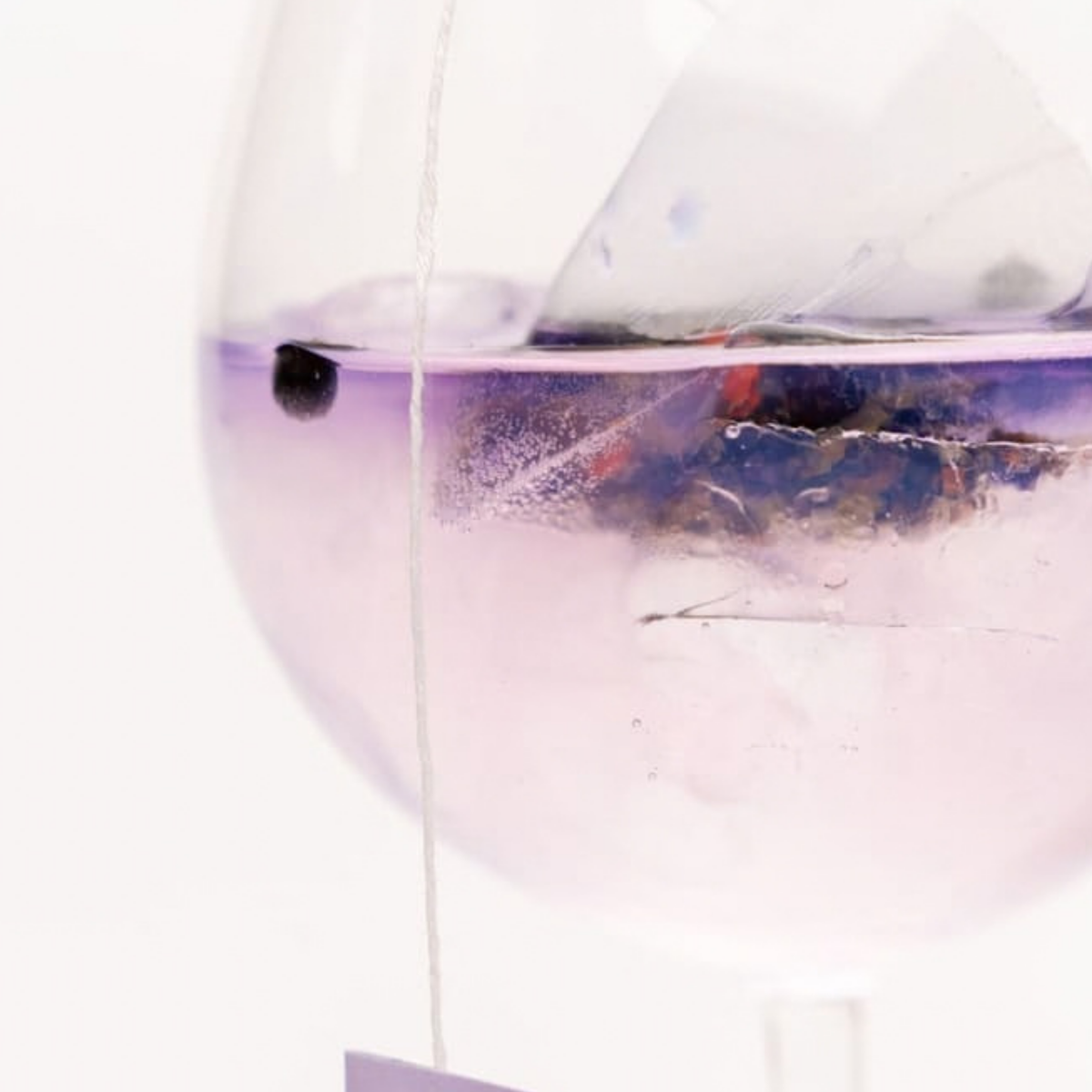 Gros plan sur le sachet Purple Me qui infuse dans le cocktail